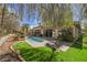 Aerial angled view of the backyard featuring mature landscaping, patio, pool, and luscious green lawn at 2805 High Sail Ct, Las Vegas, NV 89117