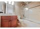 Bathroom features a wood vanity cabinet and a shower-bathtub combination with marble-style tile surround at 2805 High Sail Ct, Las Vegas, NV 89117