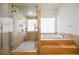Bathroom featuring a soaking tub, glass enclosed shower, marble countertop and flooring at 2805 High Sail Ct, Las Vegas, NV 89117