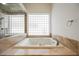 Bright bathroom featuring a soaking tub, marble countertop, and a window letting in natural light at 2805 High Sail Ct, Las Vegas, NV 89117
