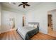 Cozy bedroom featuring hardwood floors, a modern ceiling fan, and access to an en-suite bathroom at 2805 High Sail Ct, Las Vegas, NV 89117