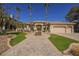 Elegant single-story home featuring a well-manicured lawn, a circular driveway, and three tall palm trees at 2805 High Sail Ct, Las Vegas, NV 89117