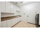 Bright laundry room is equipped with a sink, granite counters, ample cabinet space and a modern washer/dryer set at 2805 High Sail Ct, Las Vegas, NV 89117