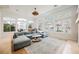 Bright, open living room with a large sectional sofa, fireplace, and walls of windows at 2805 High Sail Ct, Las Vegas, NV 89117