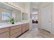 Bright bathroom with double sinks, large mirror and door leading to bedroom area at 2864 Sumter Valley Cir, Henderson, NV 89052