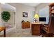 Well-lit home office with custom built-in shelving, a wooden desk, and neutral decor at 2864 Sumter Valley Cir, Henderson, NV 89052