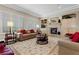 Cozy living room with plantation shutters, sofas, fireplace, and stylish area rug at 2864 Sumter Valley Cir, Henderson, NV 89052
