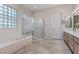 Modern main bathroom showcasing a soaking tub, glass shower, and double vanity with modern fixtures at 2864 Sumter Valley Cir, Henderson, NV 89052