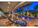 A covered patio provides shade near a pool with a waterfall and is surrounded by lounge chairs at 3051 Traverse Creek Ln, Las Vegas, NV 89135