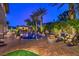 Backyard features a sparkling pool, outdoor kitchen, and cozy fire pit area at 3051 Traverse Creek Ln, Las Vegas, NV 89135