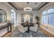 Elegant dining room with a round table, stylish chairs, decorative chandelier, and natural light at 3051 Traverse Creek Ln, Las Vegas, NV 89135