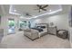 This primary bedroom features double ceiling fans, neutral colors, and a sitting area overlooking the backyard at 3051 Traverse Creek Ln, Las Vegas, NV 89135