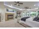 Primary bedroom boasts a tiled fireplace, tv, and bay windows with views to the outside oasis at 3051 Traverse Creek Ln, Las Vegas, NV 89135