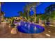 Beautiful backyard pool with palm trees and lush landscaping, creating a relaxing oasis at 3051 Traverse Creek Ln, Las Vegas, NV 89135