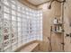 Neutral tiled shower featuring a glass block window, built in bench, and a hand held shower wand at 3051 Traverse Creek Ln, Las Vegas, NV 89135