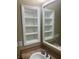 Close-up of bathroom sink with mirrored cabinet, framed shelves and tiled floor at 32 Via Vasari # 103, Henderson, NV 89011