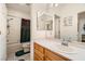 Well-lit bathroom showcasing a single sink vanity, large mirror, tile flooring, and a shower-tub combo with curtain at 3290 Vicki Ave, Las Vegas, NV 89139