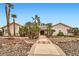 Charming single-story home featuring lush landscaping, a stone walkway, mature trees, and solar panels at 3290 Vicki Ave, Las Vegas, NV 89139