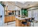 Stylish kitchen with granite counters, island seating, tile floors, and access to an adjacent living space at 3290 Vicki Ave, Las Vegas, NV 89139