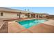 An in-ground swimming pool with clear blue water is nestled in a backyard with palm trees at 3290 Vicki Ave, Las Vegas, NV 89139