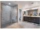Bathroom featuring a dual sink vanity and a separate shower with marble tile surround at 356 Silva Pl, Henderson, NV 89011