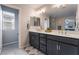 Bathroom featuring double sinks with a white counter and dark cabinets, with a large mirror at 356 Silva Pl, Henderson, NV 89011