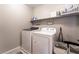 Convenient laundry room equipped with a washer, dryer, and storage shelf at 356 Silva Pl, Henderson, NV 89011