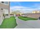 Landscaped backyard featuring a hammock and a paved walkway leading to an outdoor play area at 3738 Falcon Springs Dr, Las Vegas, NV 89147