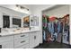 Bathroom featuring dual sinks, white countertops and cabinets, black accents, and walk in closet at 3738 Falcon Springs Dr, Las Vegas, NV 89147