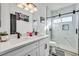 Modern bathroom with dual sinks, sleek lighting, walk-in shower, and marble tile at 3738 Falcon Springs Dr, Las Vegas, NV 89147