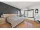 Spacious bedroom featuring a large bed, wood-look flooring, neutral walls, and window with modern shutters at 3738 Falcon Springs Dr, Las Vegas, NV 89147