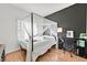 Bright bedroom features a four poster bed with white and grey bedding, and a dark accent wall at 3738 Falcon Springs Dr, Las Vegas, NV 89147