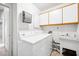 A functional laundry room with washer, dryer, storage cabinets, and a utility sink at 3854 Spruceview Ct, Las Vegas, NV 89147