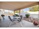Relaxing covered patio with table and chairs overlooking a serene garden, ideal for entertaining at 3854 Spruceview Ct, Las Vegas, NV 89147