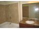 Bright bathroom featuring a bathtub and shower with neutral tile and granite countertop at 4050 Pacific Harbors Dr # 107, Las Vegas, NV 89121
