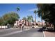 Gated community entrance with mature landscaping and palm trees under a clear blue sky at 4050 Pacific Harbors Dr # 245, Las Vegas, NV 89121