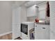 Laundry room with white appliances, storage shelves, and tile flooring at 4244 Totano Dr, North Las Vegas, NV 89032