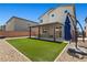Spacious backyard with artificial turf and a covered patio, perfect for outdoor enjoyment at 438 Shimmering Sands Ave, North Las Vegas, NV 89031