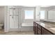 Bright bathroom featuring a glass shower, soaking tub with white tile surround, and a double-sink vanity at 438 Shimmering Sands Ave, North Las Vegas, NV 89031