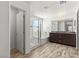 Bathroom features a walk-in glass shower, separate soaking tub, double sink vanity, and wood-style flooring at 438 Shimmering Sands Ave, North Las Vegas, NV 89031