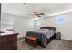 Carpeted bedroom features a ceiling fan, large bed with pillows, and side tables in neutral color palette at 438 Shimmering Sands Ave, North Las Vegas, NV 89031