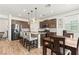 Well-lit kitchen features stainless steel appliances, stylish lighting, granite counters, and an island with bar seating at 438 Shimmering Sands Ave, North Las Vegas, NV 89031