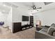 Carpeted living room with a ceiling fan, sectional sofa, and a media center under a flat screen TV at 438 Shimmering Sands Ave, North Las Vegas, NV 89031