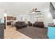 Spacious living room with tile floors, ceiling fan, large window, open floor plan, and brown reclining sofas at 438 Shimmering Sands Ave, North Las Vegas, NV 89031