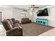 Spacious living room features an open floor plan, ceiling fan, tile flooring, and reclining sofas at 438 Shimmering Sands Ave, North Las Vegas, NV 89031