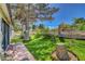 Serene backyard featuring lush artificial grass, mature tree, and a cozy patio area at 4905 Ocean Shores Way, Las Vegas, NV 89130