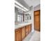 This bathroom features double sinks, wood cabinets, a shower stall, and tile flooring at 4905 Ocean Shores Way, Las Vegas, NV 89130