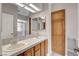 This bathroom features double sinks, wood cabinets, a shower stall, and tile flooring at 4905 Ocean Shores Way, Las Vegas, NV 89130