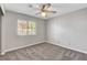 Bedroom with a ceiling fan, carpet flooring, and a window providing natural light at 4905 Ocean Shores Way, Las Vegas, NV 89130