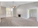 Spacious living room with a fireplace, ceiling fan, and large windows at 4905 Ocean Shores Way, Las Vegas, NV 89130